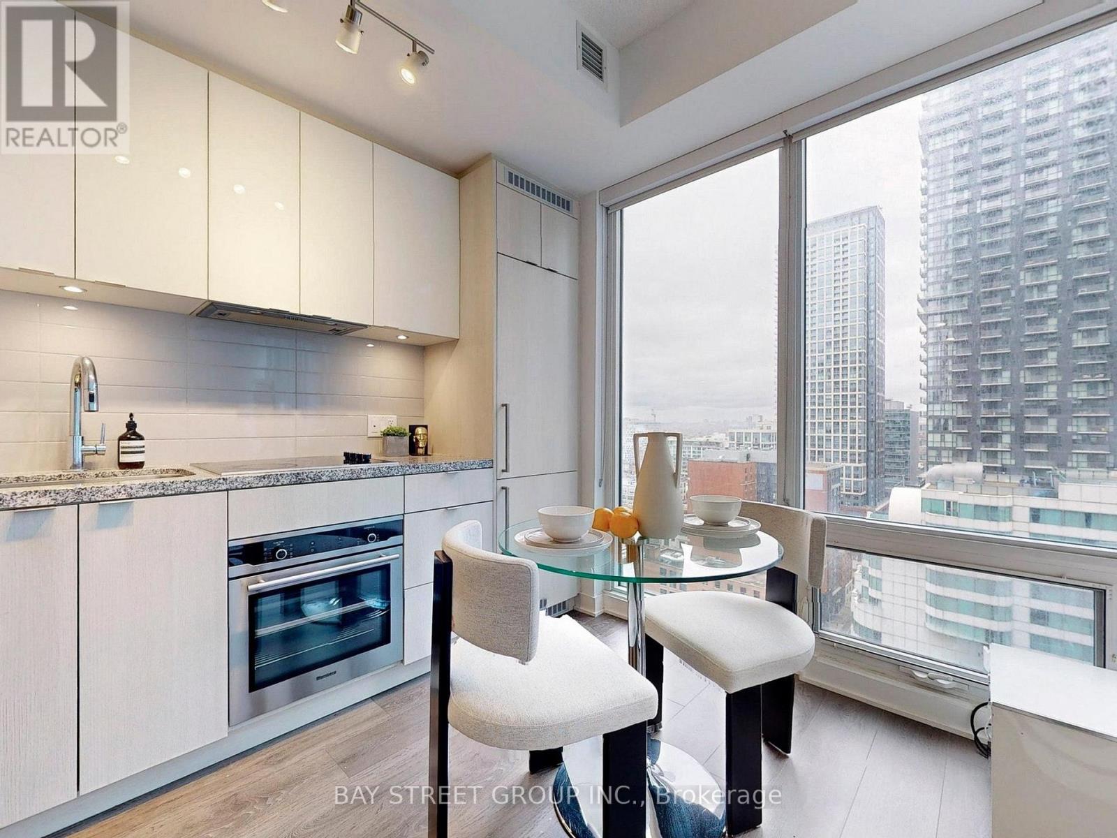A modern kitchen with white cabinets and a glass table.