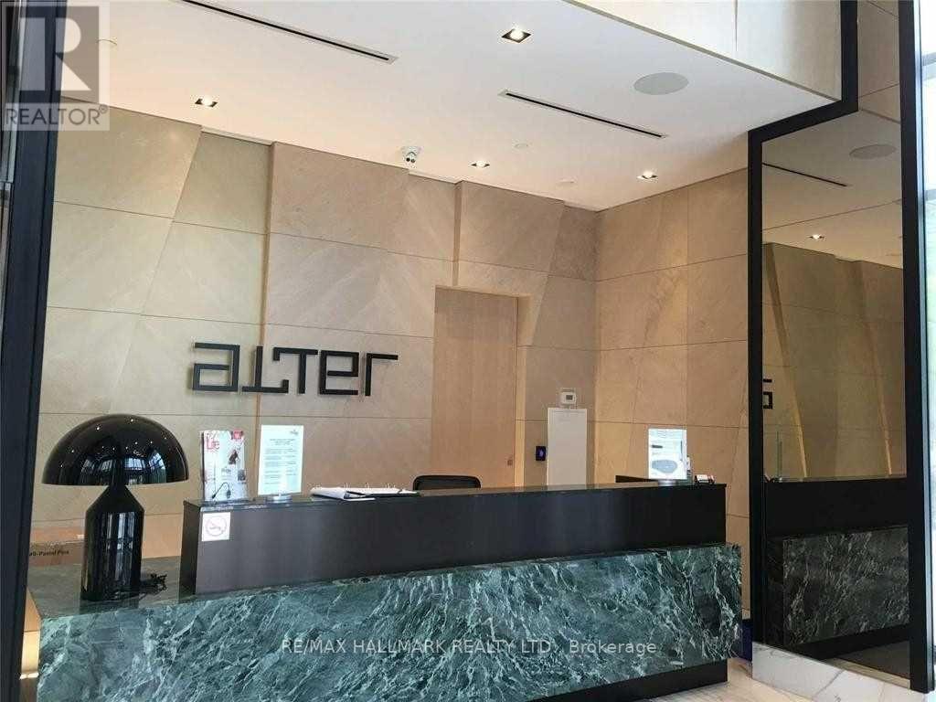 A reception area with a green marble counter and a black lamp.