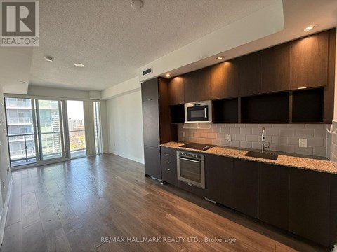 A kitchen with dark wood cabinets and a granite countertop.