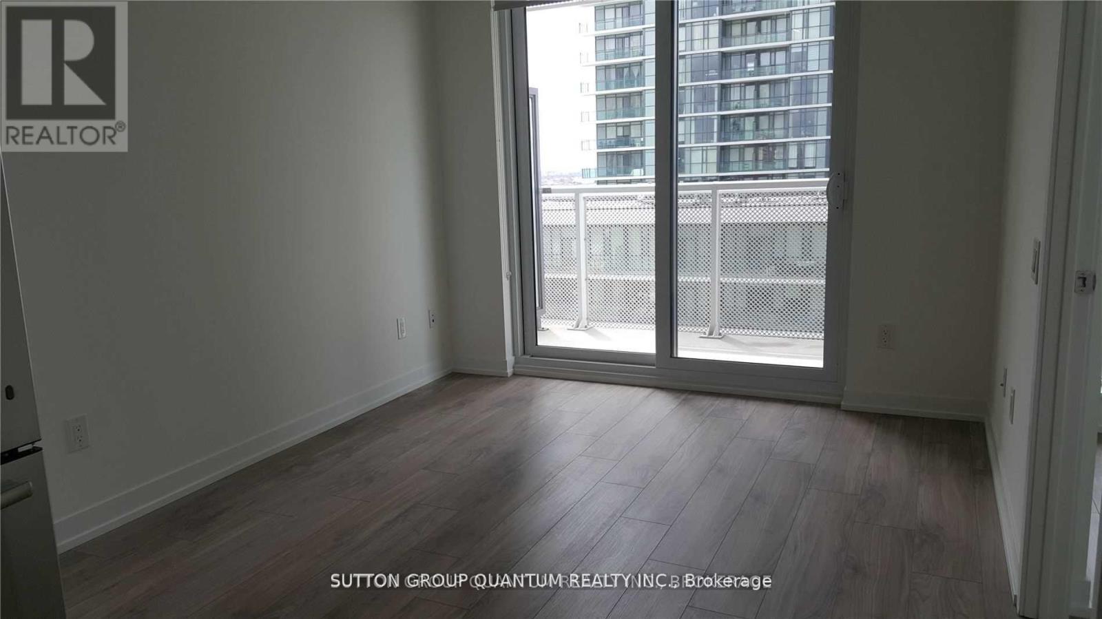 A room with a large window and wooden flooring.