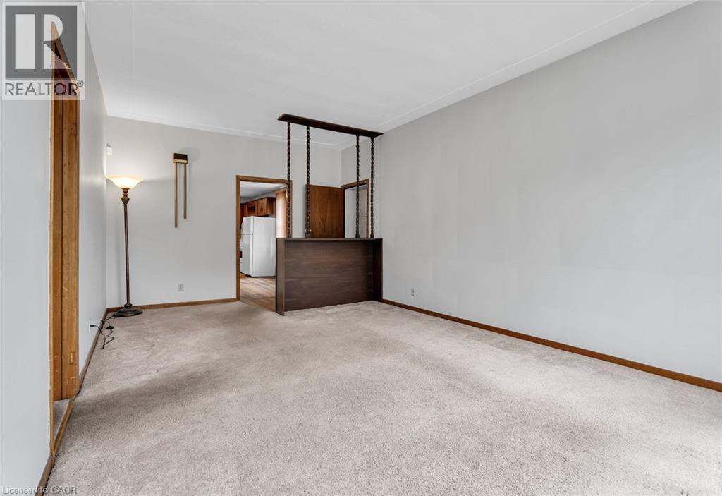 A room with a carpeted floor and a wooden staircase.