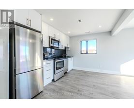 A kitchen with a refrigerator, stove, and microwave.