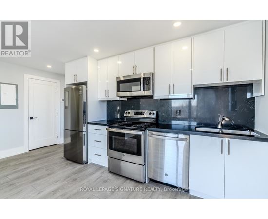 A modern kitchen with white cabinets and stainless steel appliances.