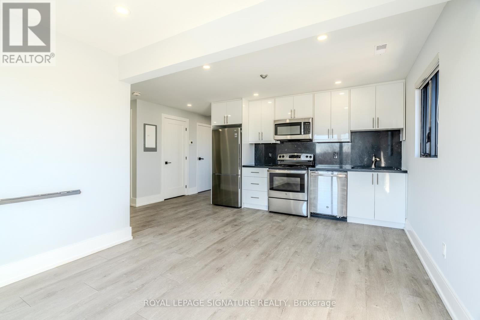 A spacious kitchen with white cabinets and stainless steel appliances.