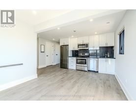 A spacious kitchen with white cabinets and stainless steel appliances.