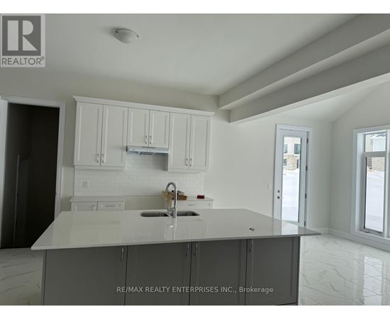 A kitchen with white cabinets and a marble countertop.