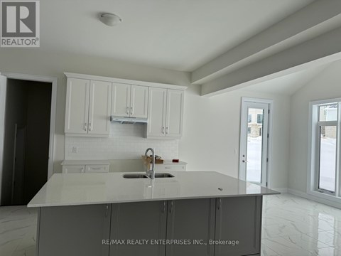 A kitchen with white cabinets and a marble countertop.