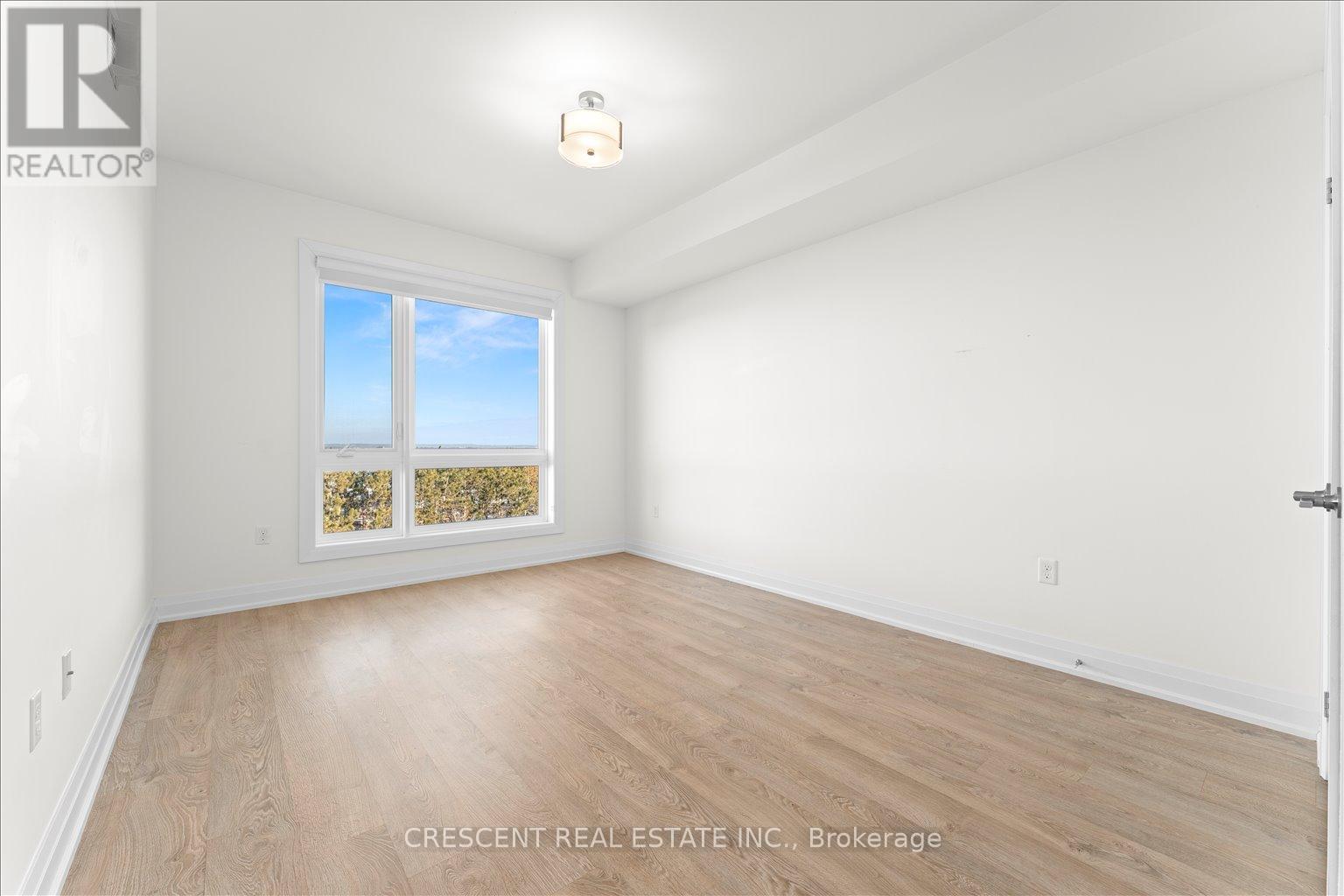A room with a window showing a view of trees and sky.