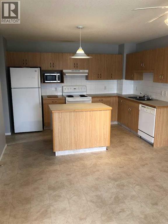 A kitchen with wooden cabinets and a white refrigerator.