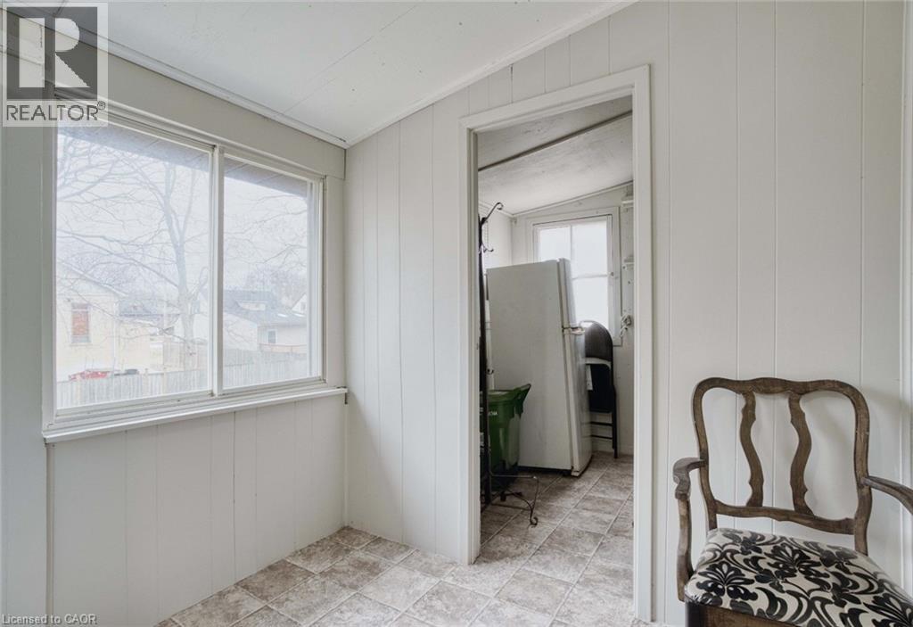 A room with a chair and a refrigerator in it.