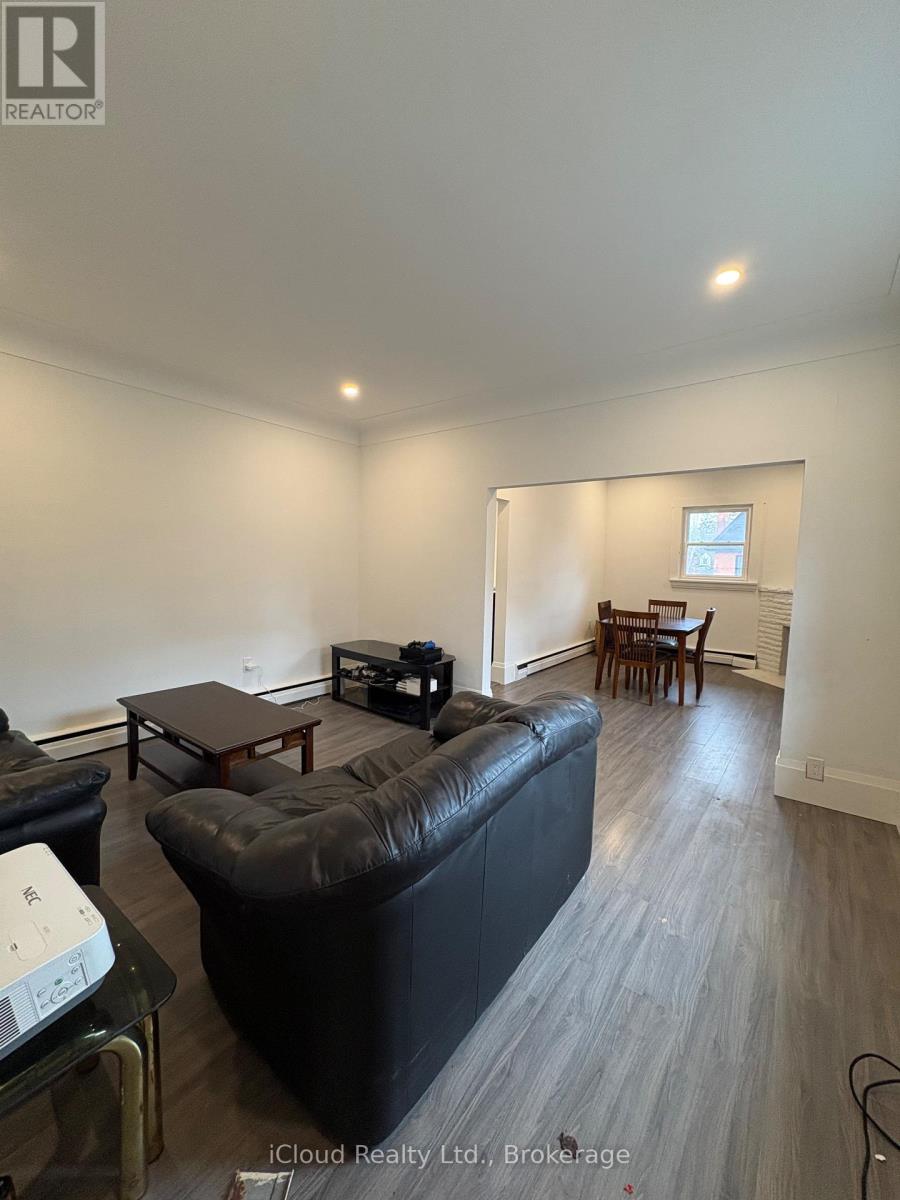 A living room with a black leather couch and a glass coffee table.