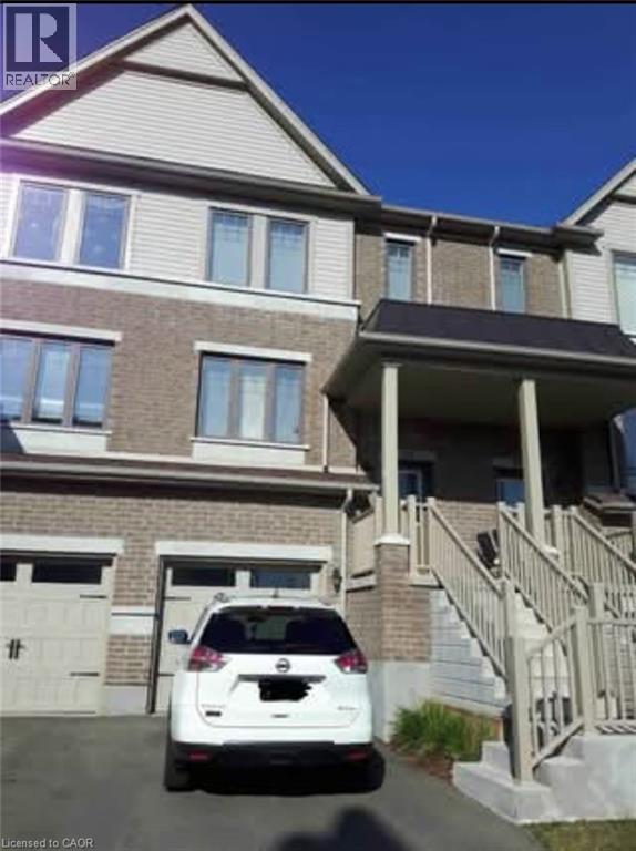 A white car is parked in front of a two-story house.