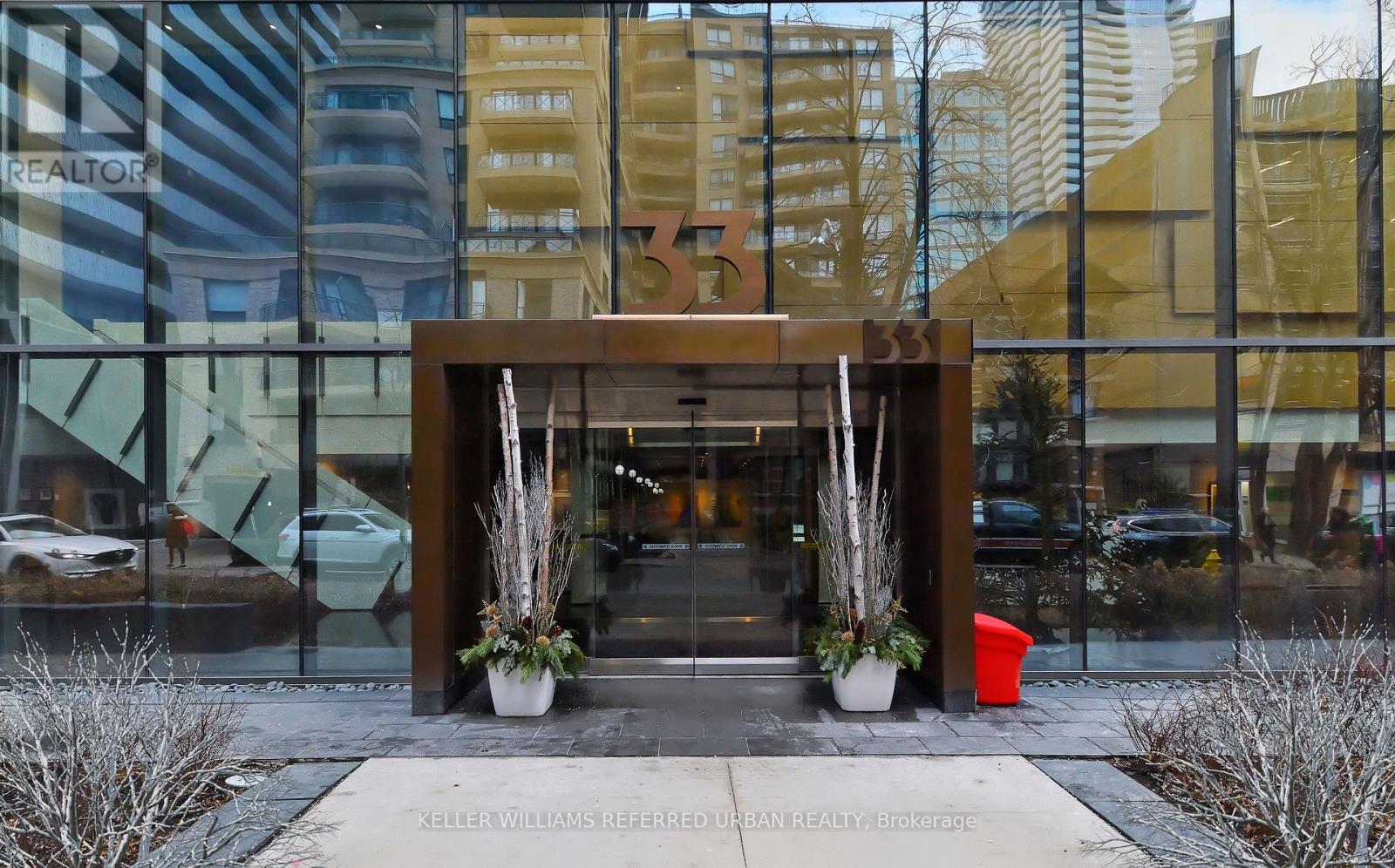The entrance to a building with a glass wall and a wooden gate.
