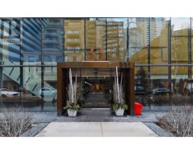 The entrance to a building with a glass wall and a wooden gate.