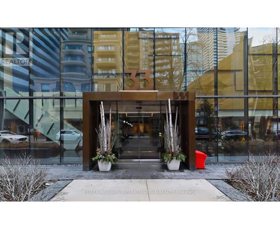 The entrance to a building with a glass wall and a wooden gate.