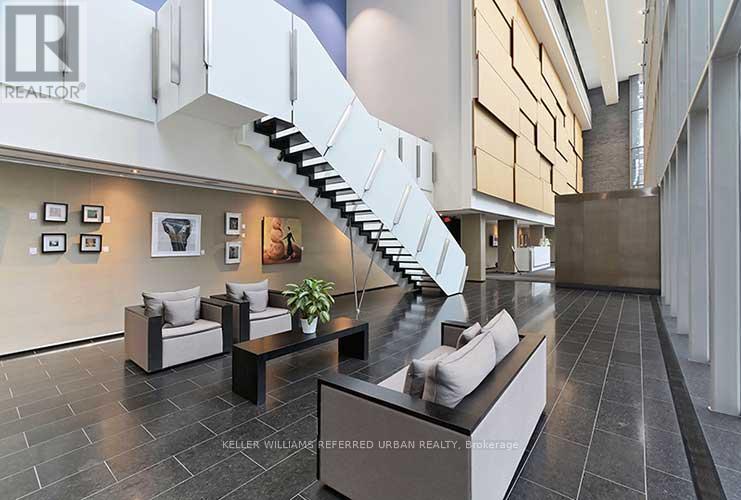 A modern living room with a staircase and a couch.
