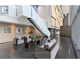 A modern living room with a staircase and a couch.