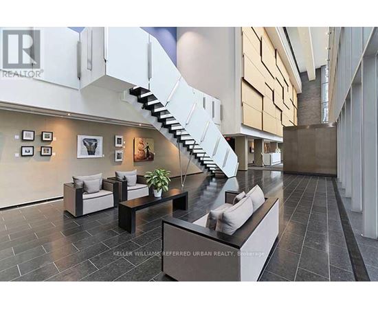 A modern living room with a staircase and a couch.
