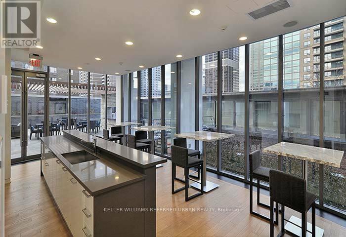 A modern kitchen with a long counter and chairs.