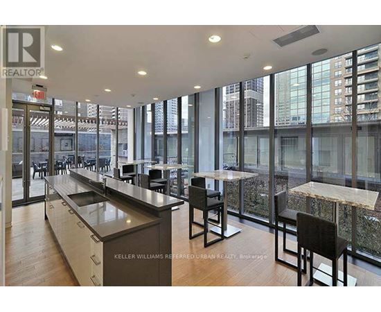 A modern kitchen with a long counter and chairs.