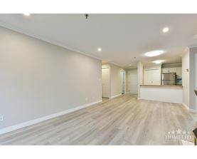 A spacious room with wooden flooring and white walls.