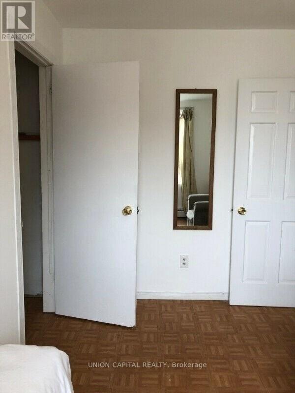 A bedroom with a bed, mirror, and two doors.