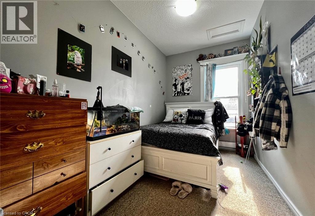 A bedroom with a bed, dresser, and window.