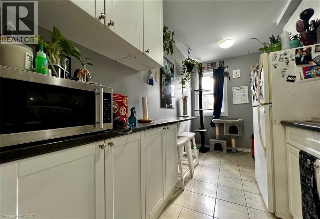 A kitchen with white cabinets and a black counter top.