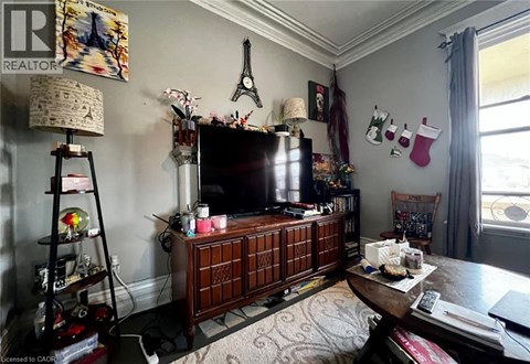 A living room with a wooden cabinet and a television on top of it.