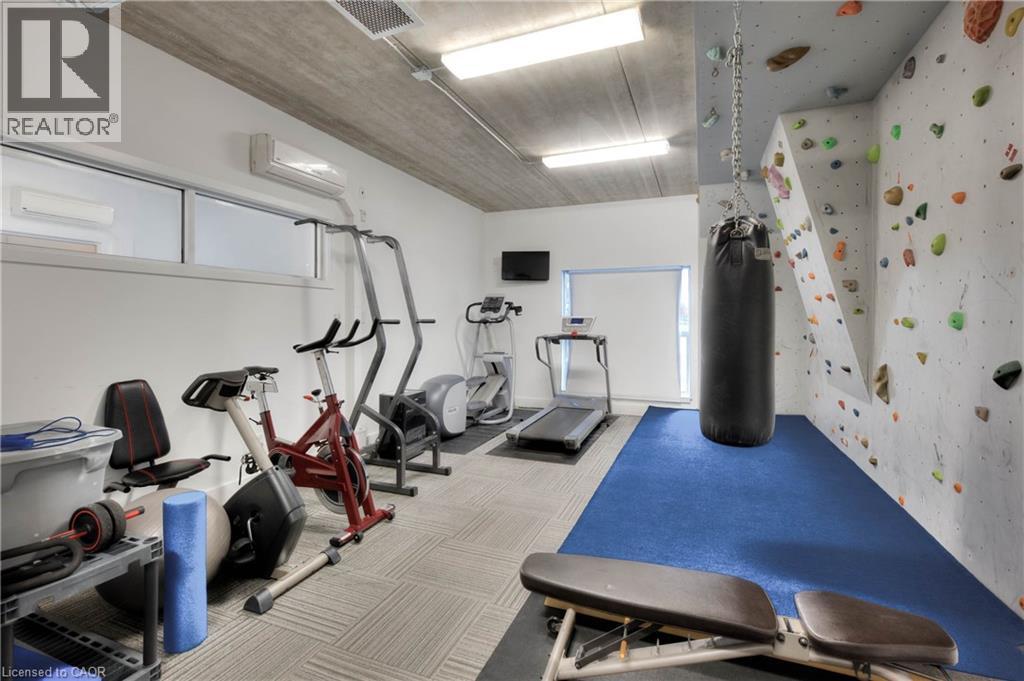 A gym with a punching bag, exercise bikes, and a climbing wall.