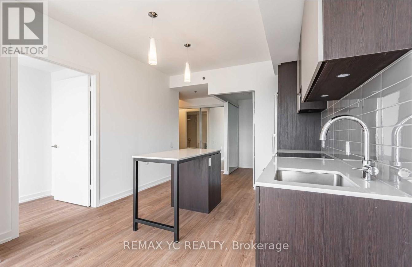 A modern kitchen with a sink and a dining table.