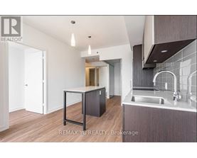 A modern kitchen with a sink and a dining table.