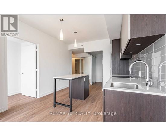 A modern kitchen with a sink and a dining table.