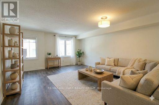 A living room with a couch, a coffee table, and a plant.