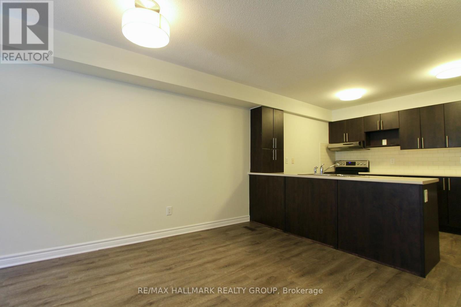 A kitchen area with dark brown cabinets and a countertop.