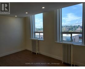 A room with two windows and a radiator on the floor.
