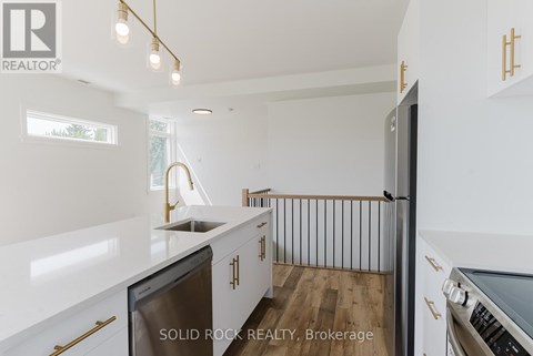 A modern kitchen with white cabinets and a stainless steel dishwasher.