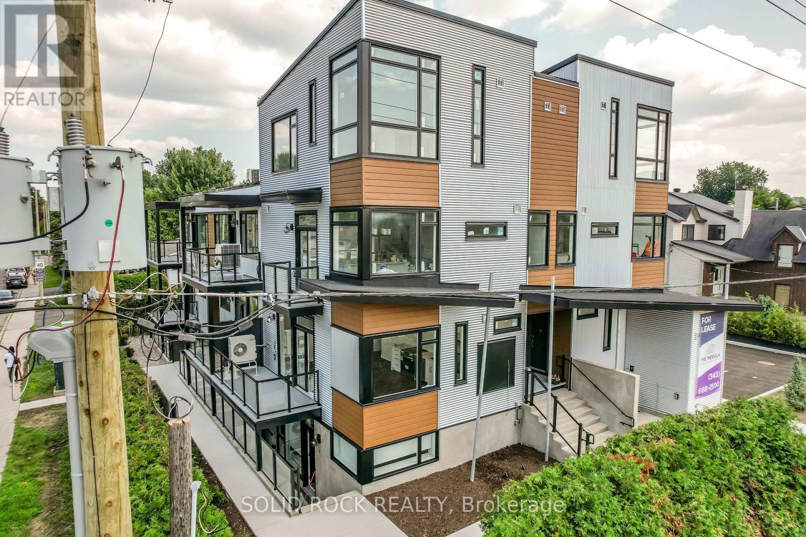 A modern multi-story building with a mix of wood and glass panels.