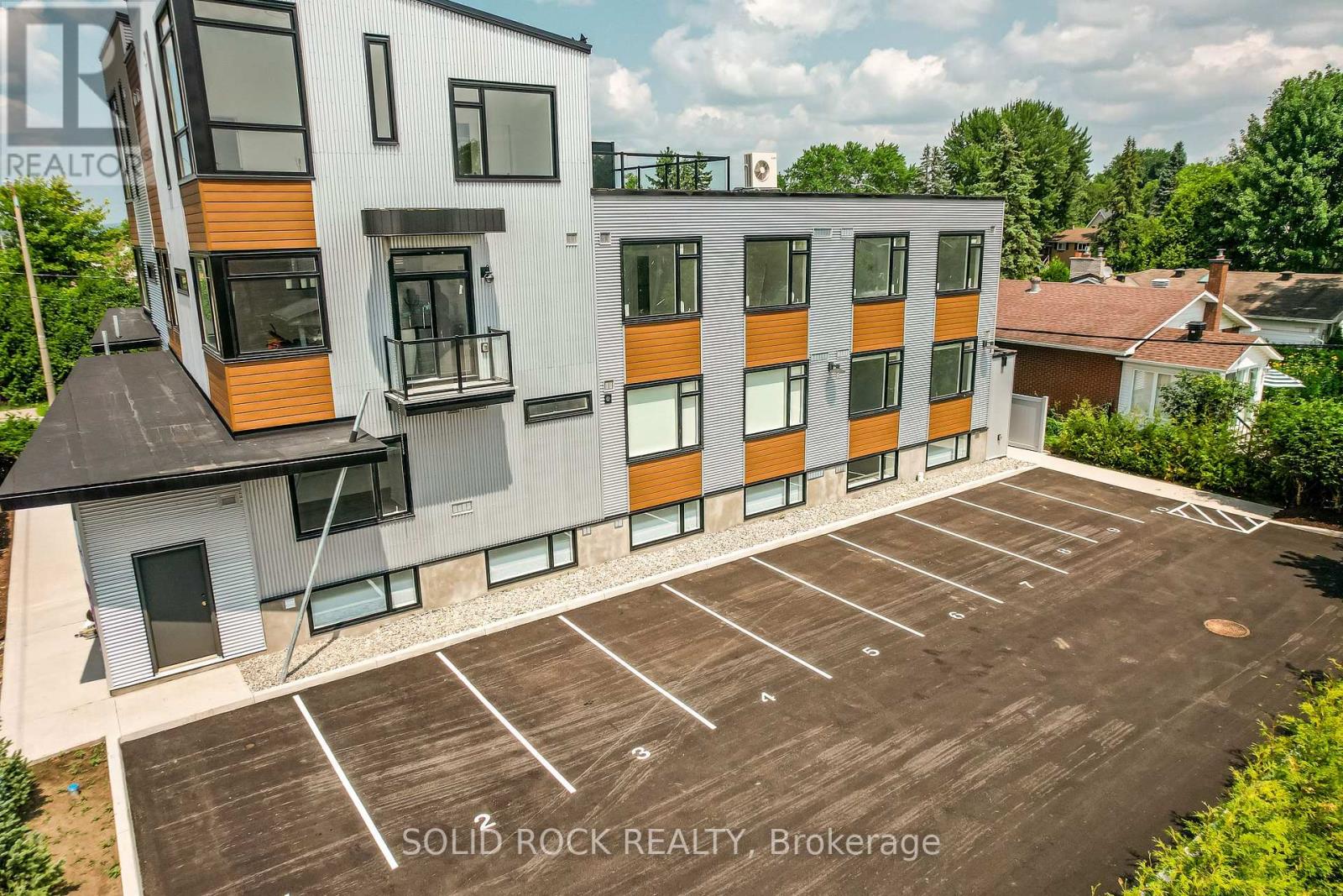A modern building with a parking lot in front of it.