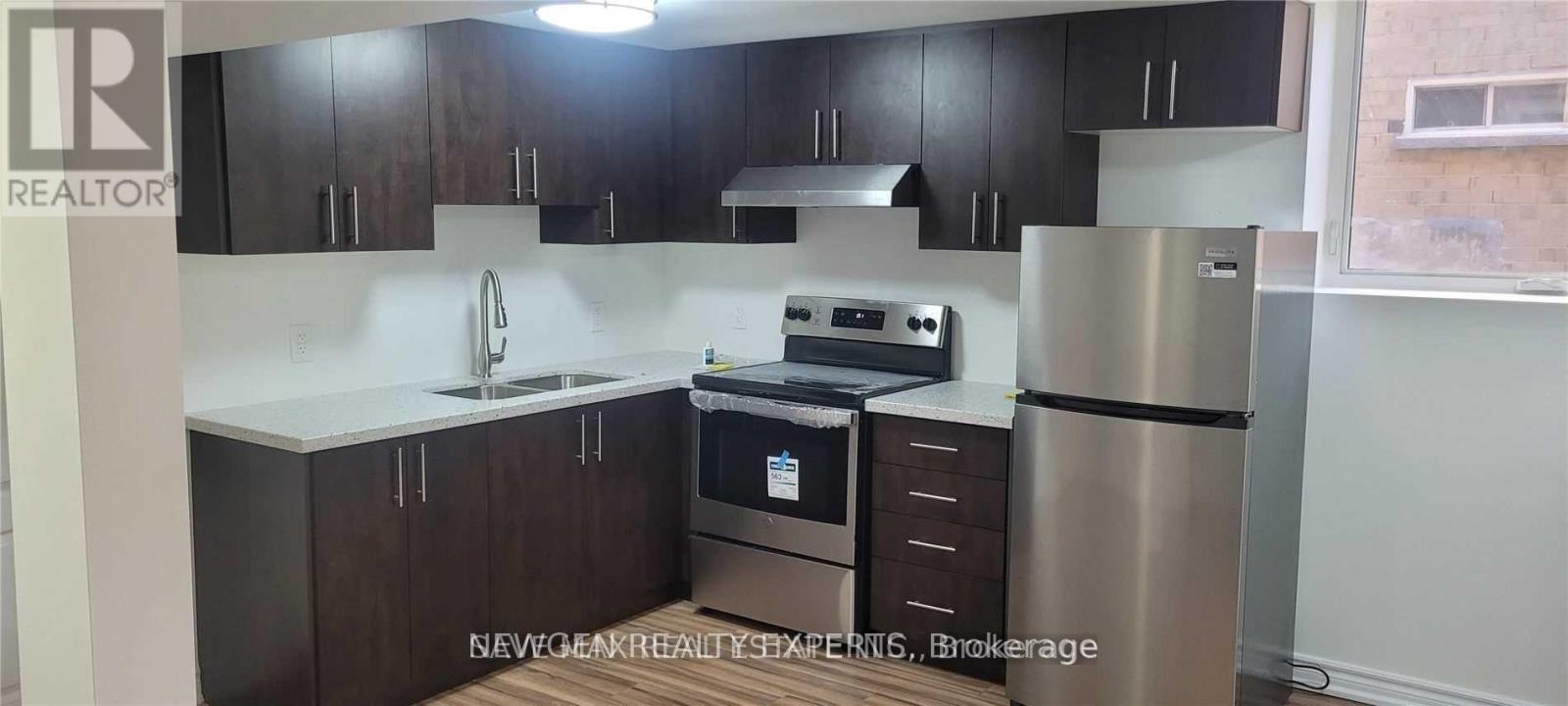 A kitchen with dark brown cabinets and stainless steel appliances.