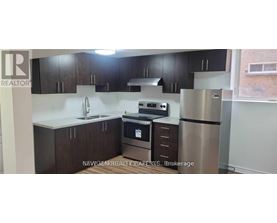 A kitchen with dark brown cabinets and stainless steel appliances.
