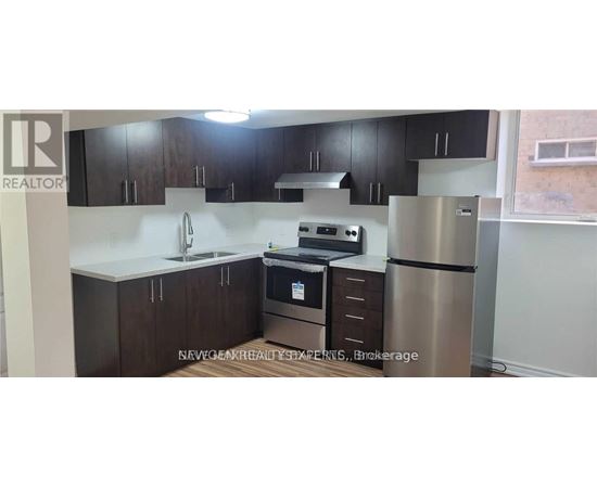 A kitchen with dark brown cabinets and stainless steel appliances.