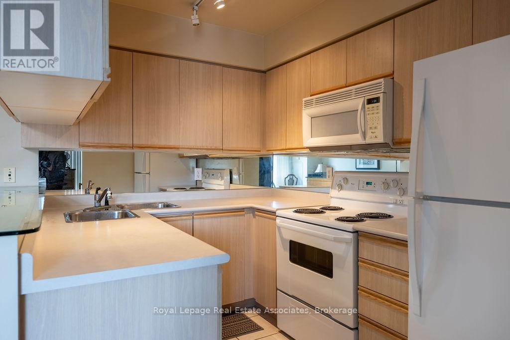 A kitchen with wooden cabinets and white appliances.