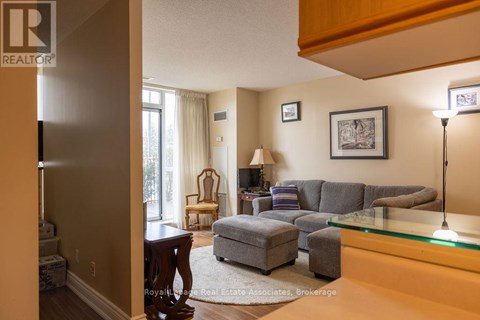A living room with a grey couch and a glass table.