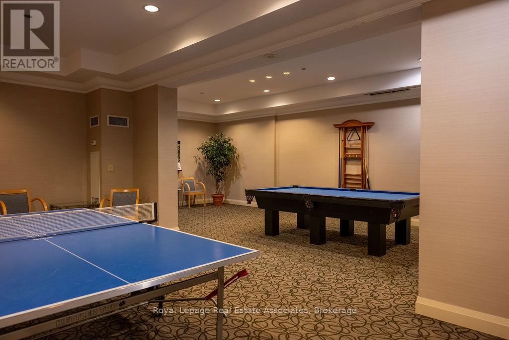 A pool table in a room with a chair and a plant.