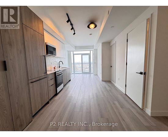 A kitchen with wooden cabinets and a microwave above the stove.