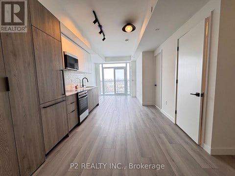 A kitchen with wooden cabinets and a microwave above the stove.