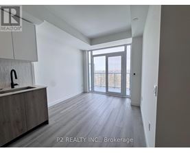 A spacious room with a sink and wooden flooring.