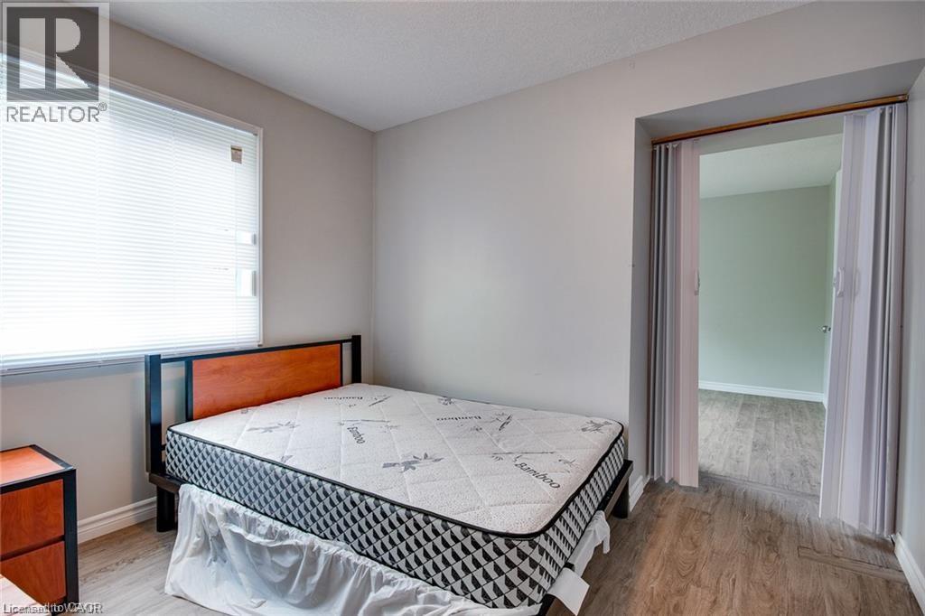 A bedroom with a bed, nightstand, and window.