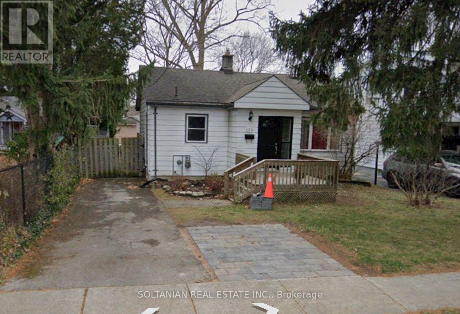 A small white house with a black door and a grey roof.